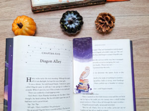 Marque-page Chouette des Livres placé dans un livre avec une décoration automnale