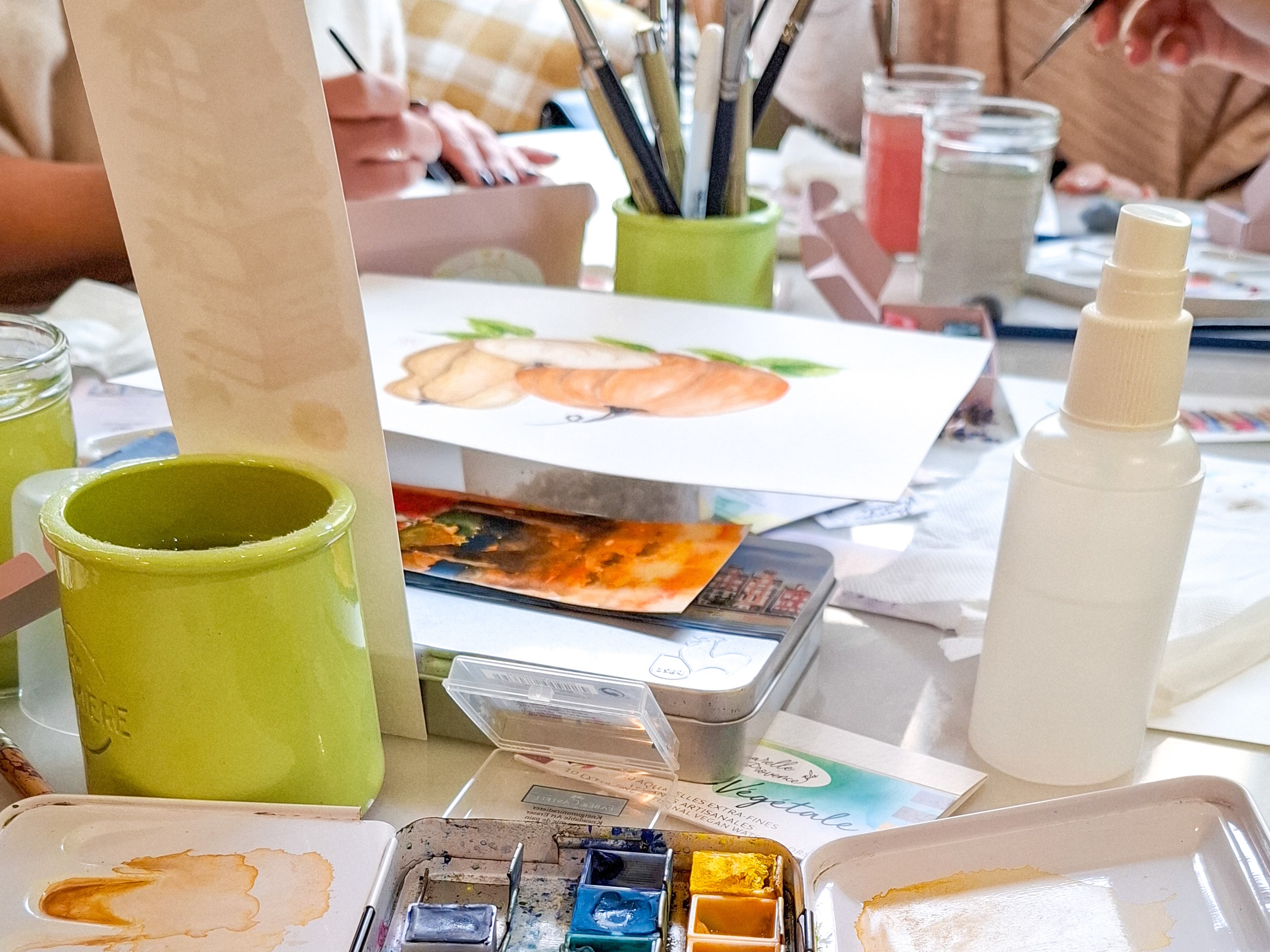 Table d’atelier d’aquarelle avec palettes, pinceaux et feuilles prêtes à peindre